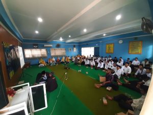 Lantai bawah, warga mengikuti dari layar proyektor